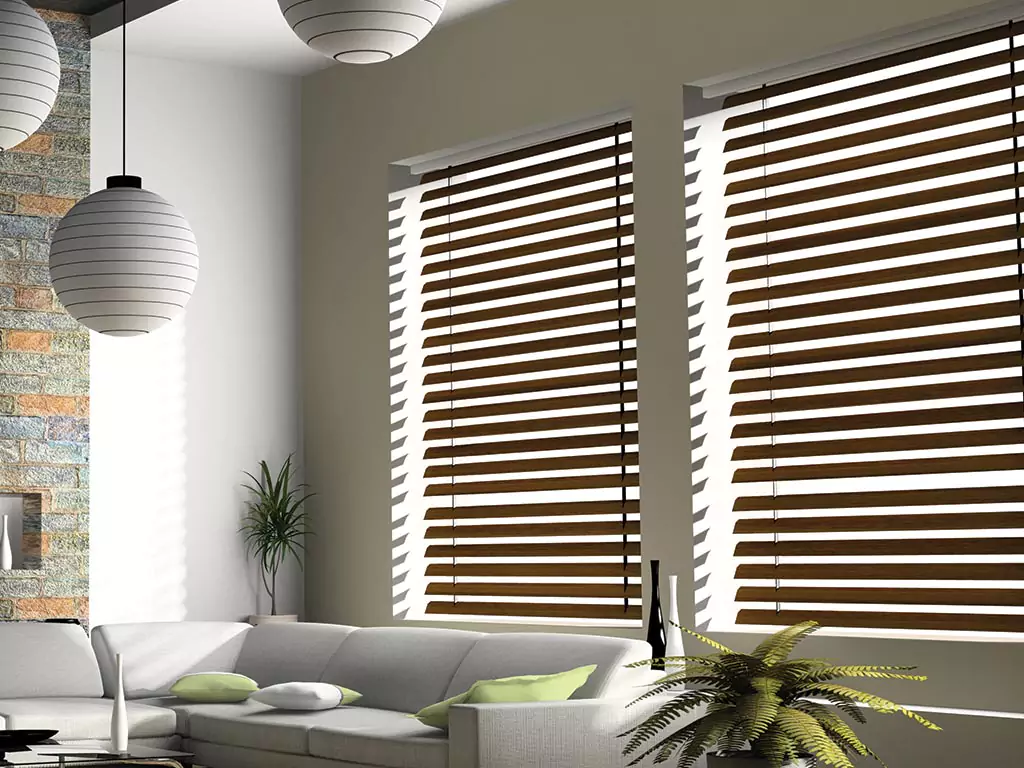portrait white Venetian blinds casting shadows on a wall